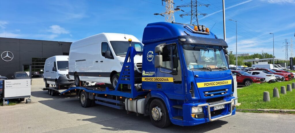 Niebieska laweta z samochodami i busami – pomoc drogowa Rzeszów